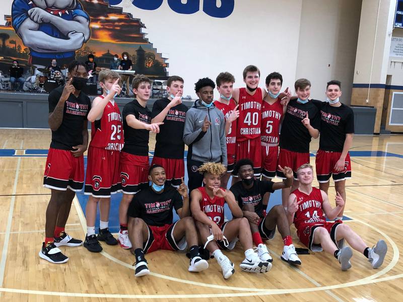The Timothy Christian boys basketball team celebrates winning the Metro Suburban Blue championship on Saturday in Riverside.