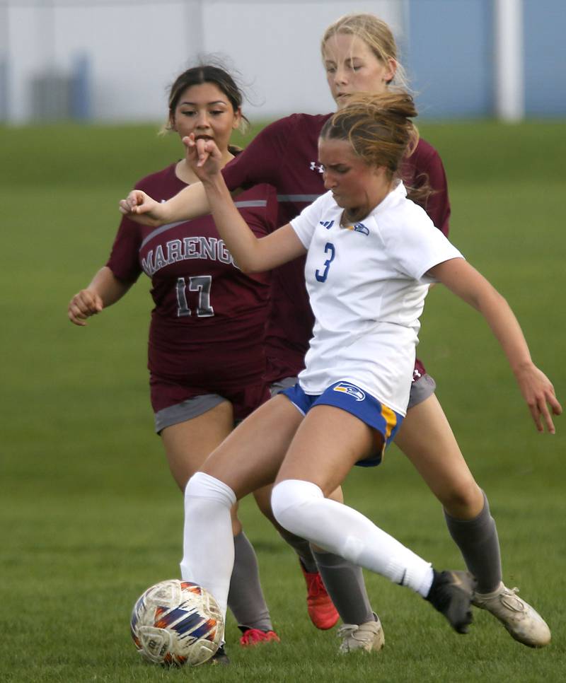 Johnsburgs Charlie Eastland takes a shot on goal in front of Marengo's Yazelin Alaniz (left)  and Sophie Hanson (center) during a Kishwaukee River Conference soccer match on Wednesday, April 15, 2026, at Marengo High School.