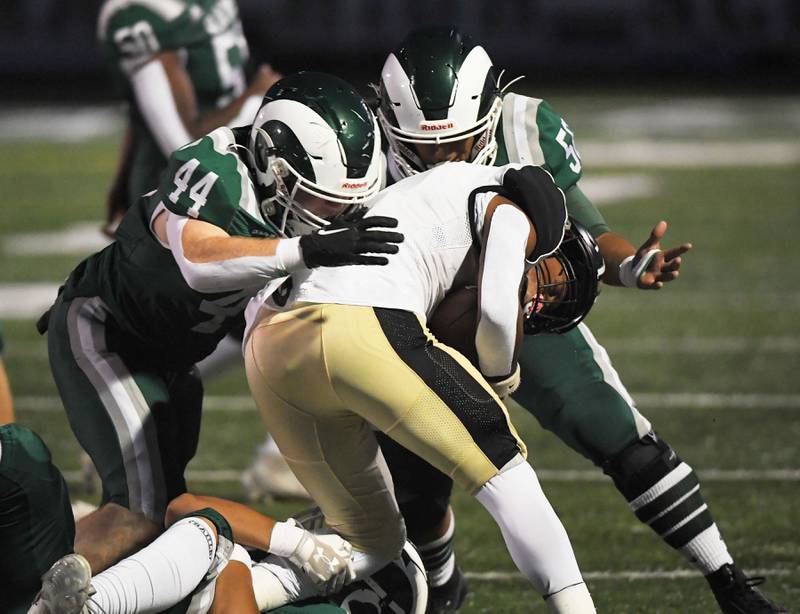 Grayslake North’s Dominique Pulliam is tackled by Grayslake Central’s Matthew Jens and Rarri Bernabe, right, in a football game at Central High School on Thursday, September 14, 2023.