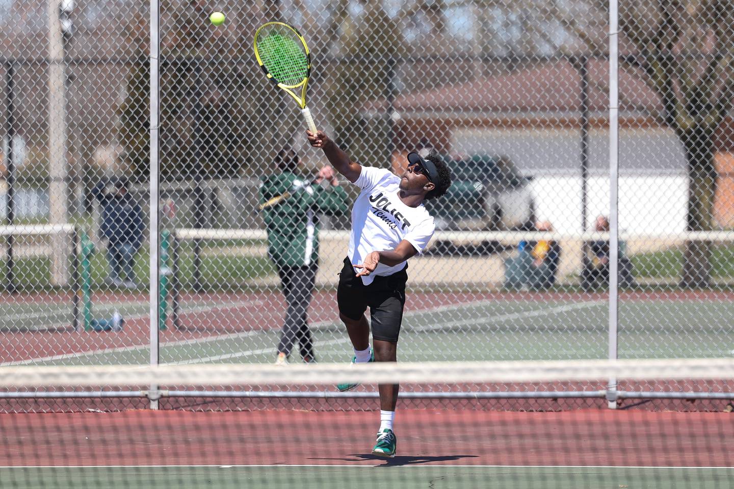 Joliet Township’s Christian Alexander serves the ball in a double match on Saturday, April 6, 2024 in Joliet.