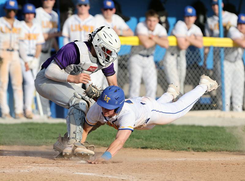 Downers Grove North catcher Jimmy Janicki tags out Lyons Township's James Georgelos at home plate during the boys varsity baseball game between Lyons Township and Downers Grove North high schools in Western Springs on Tuesday, April 11, 2023.