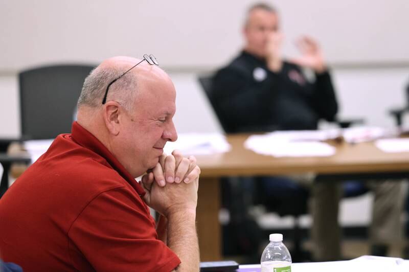 Mark Charvat, one of the two DeKalb residents who filed objections against DeKalb City Council Ward 5 alderman Scott McAdams’ election filing smiles as DeKalb Mayor Cohen Barnes speaks Friday, Jan. 13, 2023, during a City of DeKalb Electoral Board hearing. The hearing was held to decide if McAdams, who is running unopposed for DeKalb’s 5th Ward aldermanic seat, should be removed from the ballot due to objections filed by two residents regarding signatures and filing procedure.