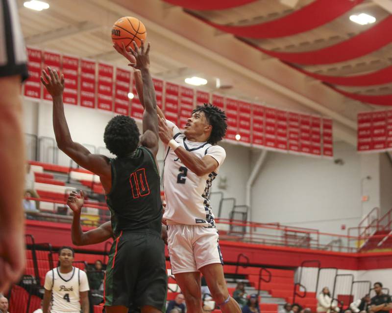 Oswego East's Jacsen Tucker (2) puts up a shot over the defense during their Hinsdale Central Holiday Classic basketball game between Morgan Park at Oswego East Saturday, Dec 27, 2025 in Hinsdale.