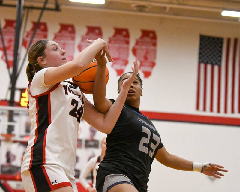Yorkville's Sloane Connell (24) and Oswego East's Inspire Fisher (23) battle for a loose ball during the game on Thursday Dec. 18, 2025, held at Yorkville High School.