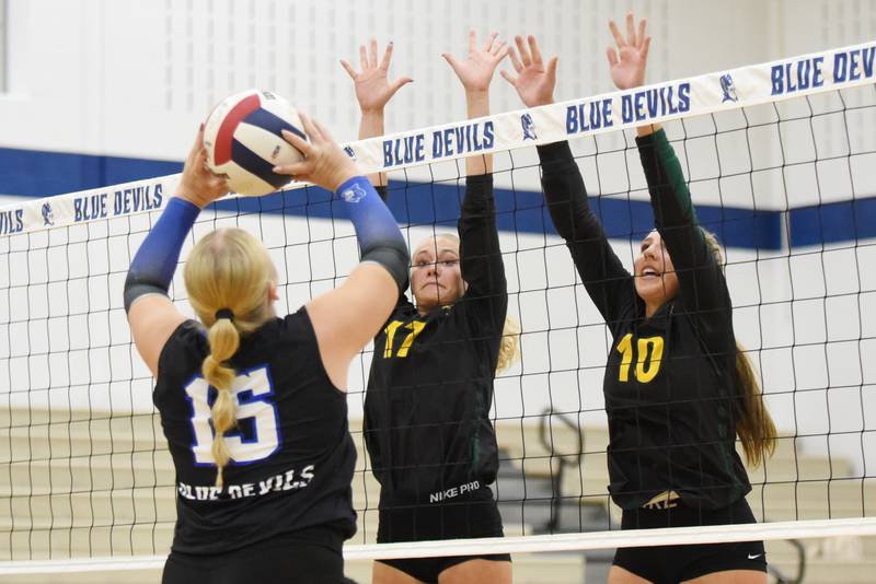 Coal City's Maggie Carlson, center, and Ava Kenney, right, look to block a set from Peotone's Ava Kosmos during a game at Peotone Thursday, Sept. 18, 2025.