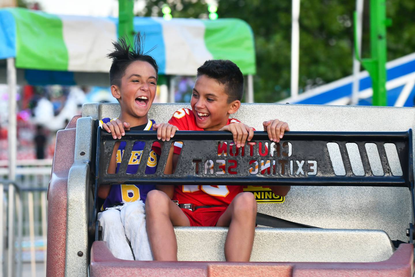 Alex, left, and Alton Ortega, 11-year-old twin brothers, of Bradley, laugh as they ride the Sizzler on during the first day of the 2024 Bourbonnais Friendship Festival.