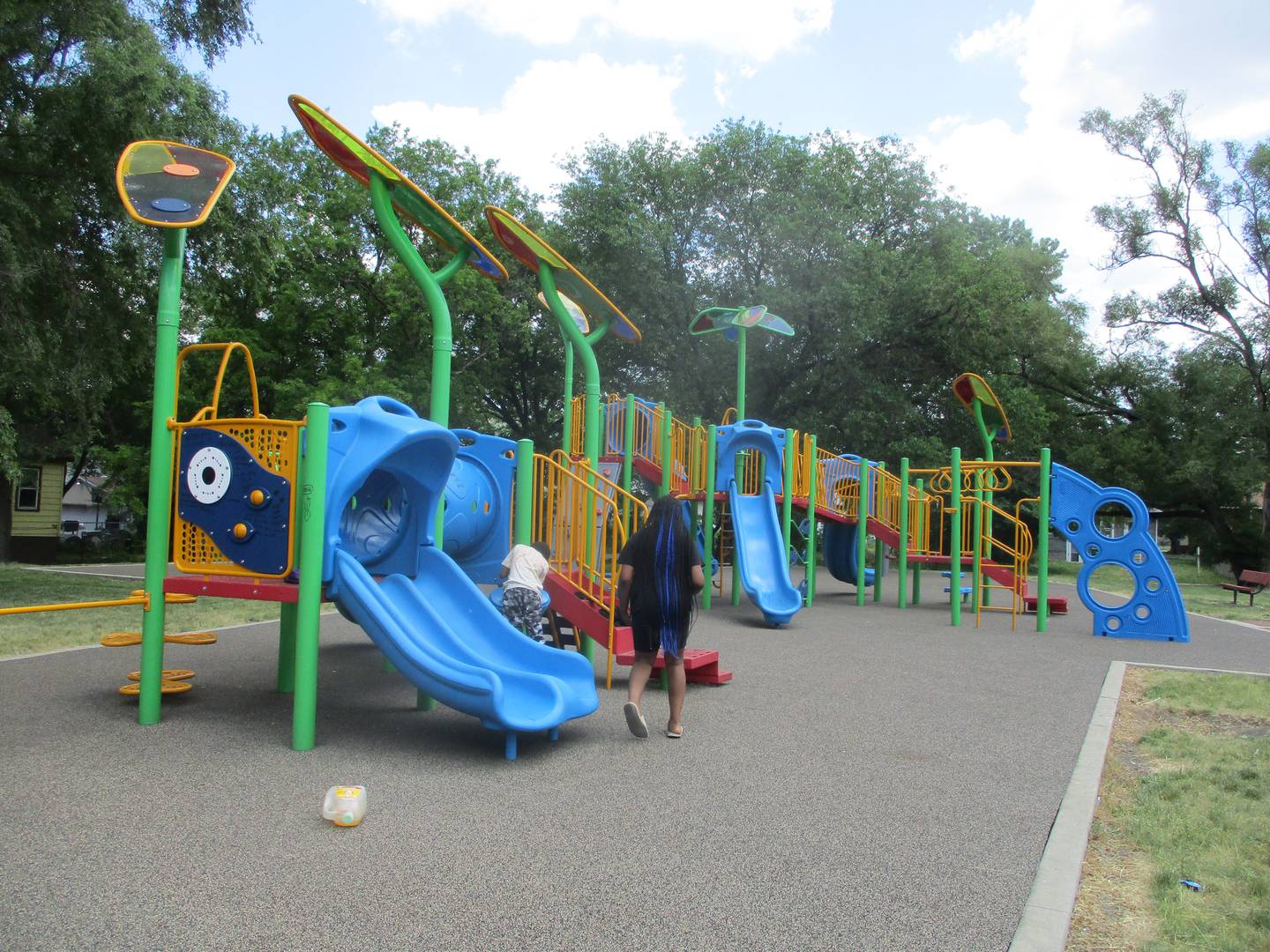 A woman and child look around the Joliet playground Wednesday, May 31, 2023, near the scene where a 16-year-old was shout Tuesday night.