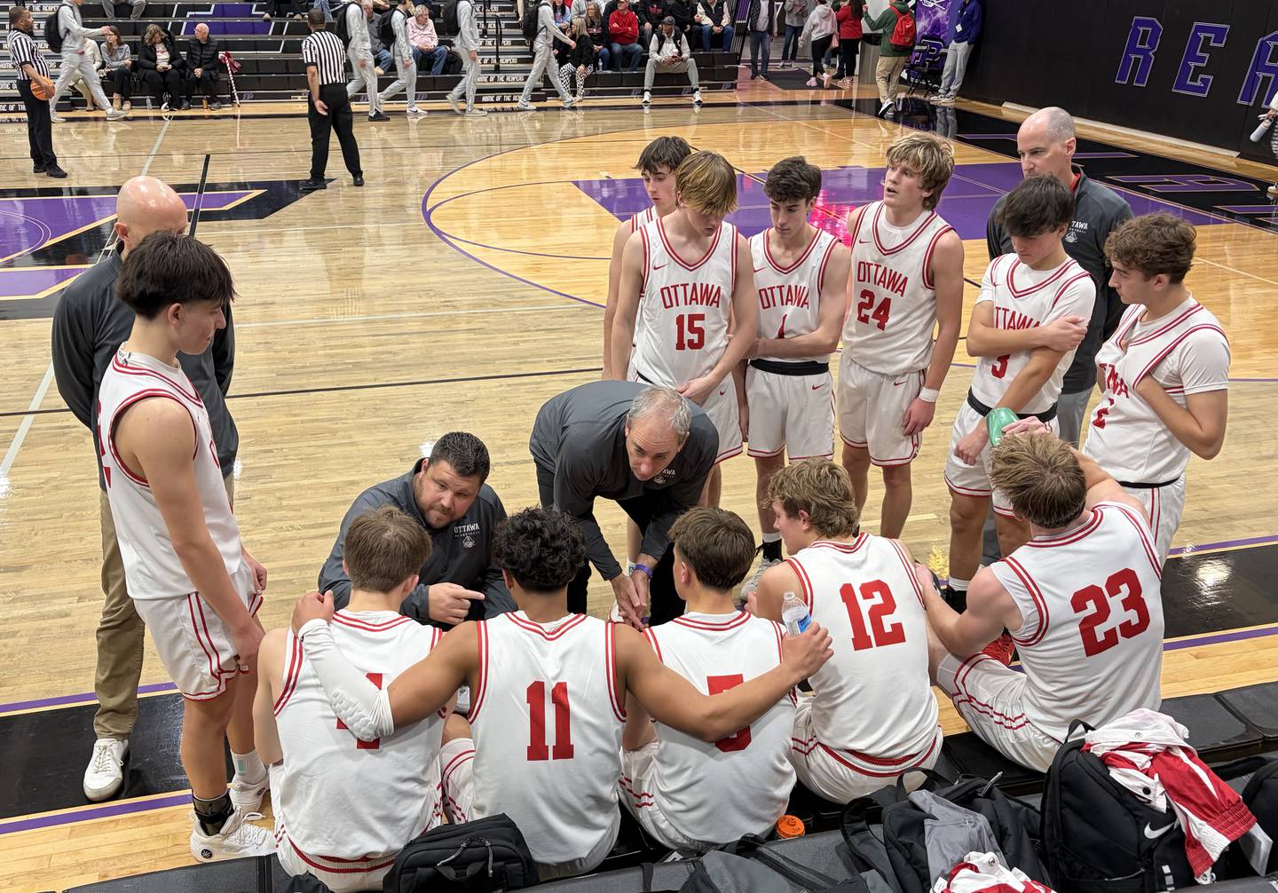 The Ottawa coaching staff, including assistant Bob Bartman and head coach Mark Cooper (in center), talk things over with the Pirates during a timeout in their 61-39 win over Northridge Prep on Friday, Dec. 26, 2025, at the Plano Christmas Classic.