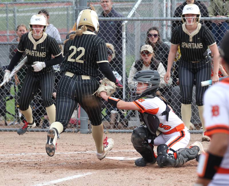 Sycamore's Annabella Johnson knocks the ball away from DeKalb's Madison Hallaron scoring a run Friday, May 2, 2025, during their game at DeKalb High School. Latimer was injured on the play.