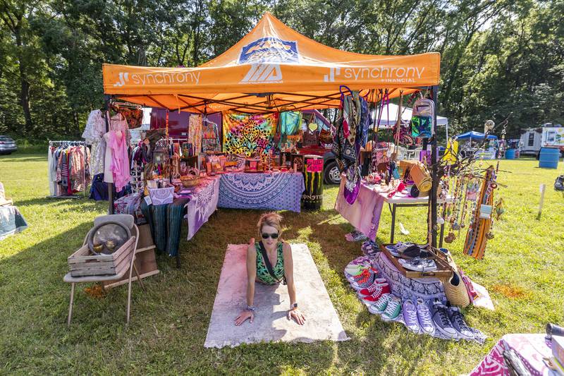 Michelle Monk of Kingston gets some yoga in Friday, July 12, 2024 while manning her booth at Herbal Roots’ Cannafest.