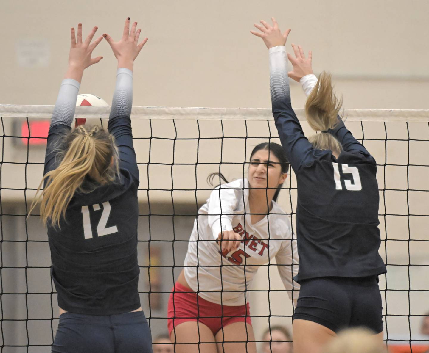 Benet’s Sophia Youssef his her shot blocked by New Trier’s Grace O'Rourke in a supersectional girls volleyball match Monday, Nov. 10, 2025 in Bartlett.