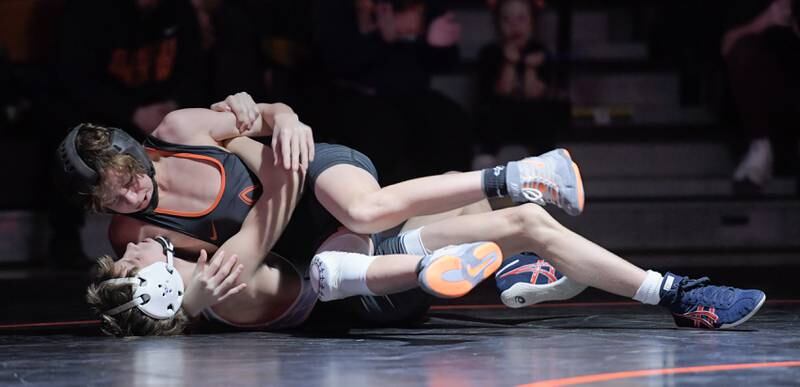 St. Charles East's Kaden Potter, top, and Marian Central's Austin Hagevold wrestle at 106 pounds during a match in St. Charles on Wednesday, December 20, 2023.