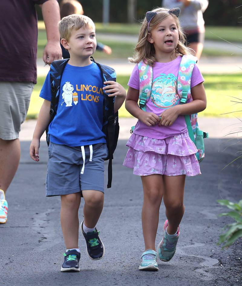 Zad Campbell, (left) a first grader at Lincoln Elementary School, arrives with his sister Avi, a second grader, for their first day of classes Wednesday, Aug. 14, 2024, at the school in DeKalb.