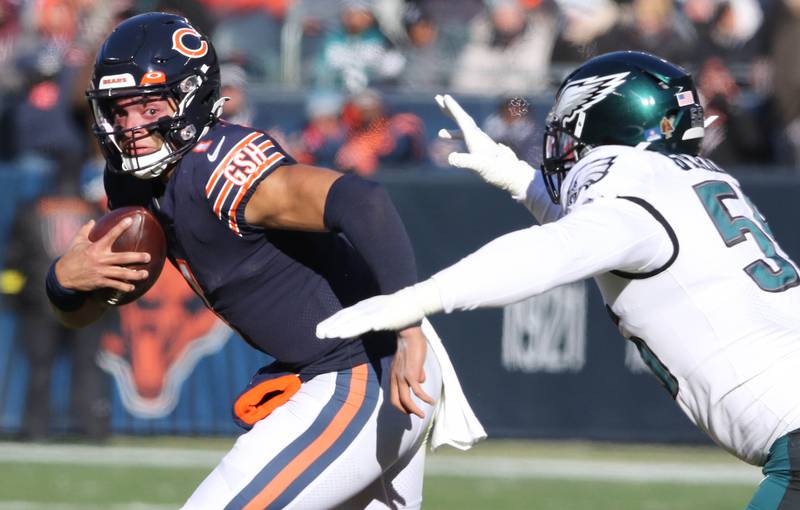 Chicago Bears quarterback Justin Fields scrambles away from the pass rush of Philadelphia Eagles defensive end Brandon Graham during their game Sunday, Dec. 18, 2022, at Soldier Field in Chicago.