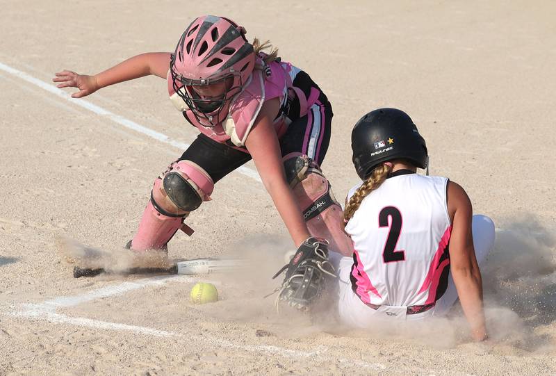 Kishwaukee Valley Storm 10u player Neve Crittenden knocks the ball out of the Poplar Grove catchers glove as she slides in to score a run Wednesday, June 21, 2023, during a scrimmage game at the Sycamore Community Sports Complex. The Kishwaukee Valley Storm is hosting the Storm Dayz tournament this weekend which draws about 70 teams and runs Friday through Sunday in Sycamore.