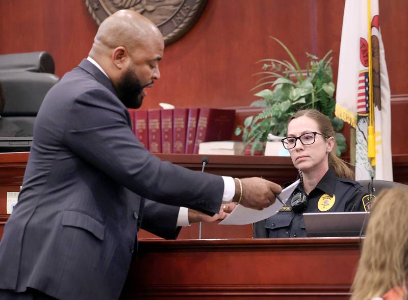 Brandon Brown, co-defense counsel for Hamza Khatatbeh, show’s Sycamore Police Sgt. Stacy Binkowski her police report Wednesday, Feb. 18, 2026, during Khatatbeh’s murder trial at the DeKalb County Courthouse in Sycamore. Khatatbeh, 17, is accused of fatally stabbing Sycamore 17-year-old Kaleb McCall in 2023.