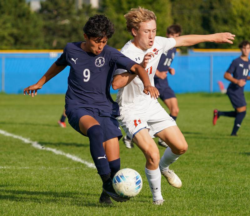 Oswego East's Jonathan Carranza (9) challenges Oswego’s Nolan Gustafson (11) for the ball during a soccer match at Oswego East High School on Tuesday, Sept. 26, 2023.