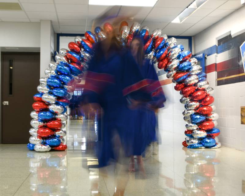 Glenbard South graduates walk through a balloon archway as they make their way to the gym for the start of the graduation ceremony on Thursday May 23, 2024, held at Glenbard South High School.