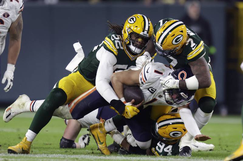 Chicago Bears quarterback Justin Fields (1) is stopped by Green Bay Packers linebacker Rashan Gary (52), linebacker Quay Walker (7) and defensive end Karl Brooks (94) during the second half Sunday, Jan. 7, 2024, in Green Bay, Wis.