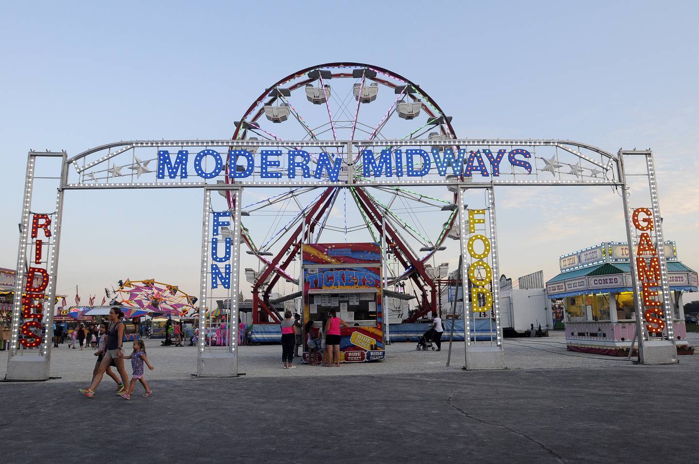 Fairgoers navigate the entrance to the Modern Midways ride area at the Kankakee County Fair.