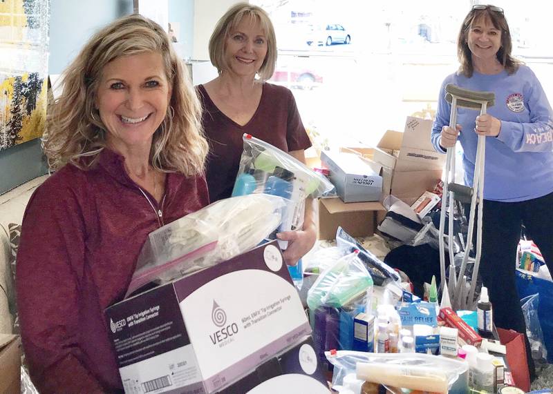 Rene Koehler (right) and community volunteers Vickie Drendel (left) and Roxanne Mairs-Hawrylewscz (center) of Naperville working to sort and pack donations from the community for Ukrainian refugees. (Photo provided)