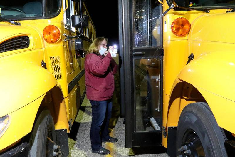 Richmond-Burton High School District 157 and Nippersink School District 2 head trainer and bus driver Laurie Bottlemy performs a morning routine daily inspection on her bus before dispatch for student transportation to Richmond-Burton High School on Thursday in Richmond.  he districts are suffering from a lack of bus drivers and substitute teachers.