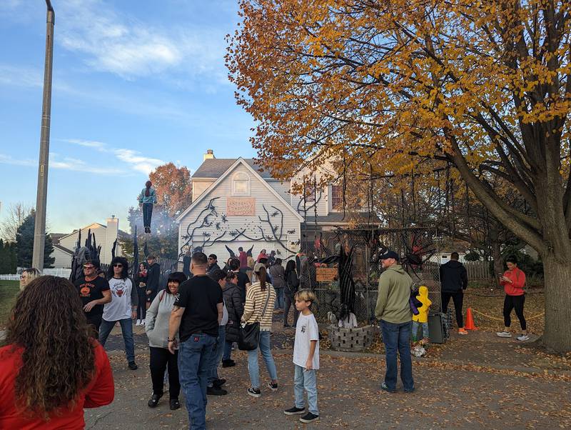 A relatively small group of people crowded around the “Stranger Things” home in Plainfield on Saturday, Oct. 29, 2022. After a video of Dave Appel and Audrey Appel posted of their 'floating Max" display went viral, thousands came out to the Appels' home to see it.