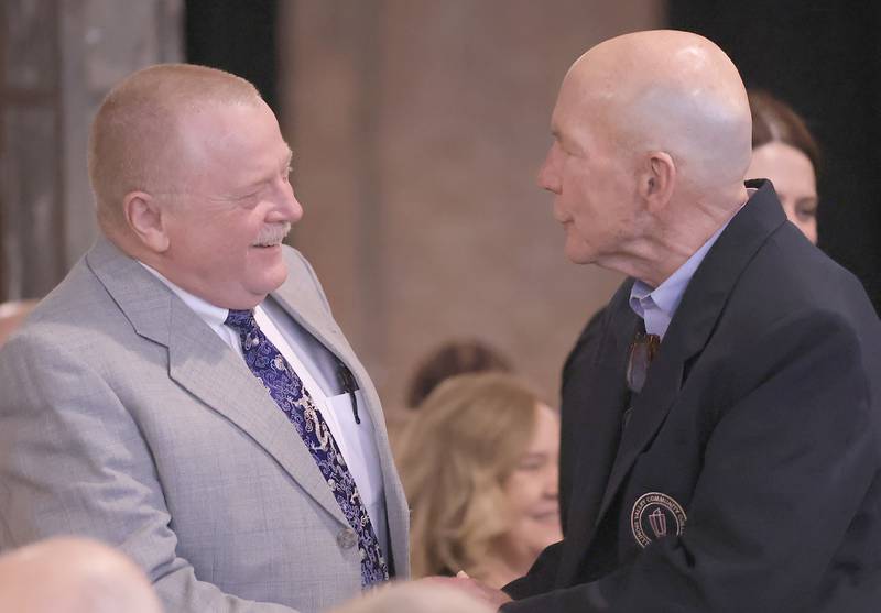 Ralph Moshage congratulates retired Illinois Valley Community College president Jerry Corcoran during the Illinois Valley Chamber of Commerce Champions of Change Awards Night on Thursday, April 10, 2025 at the Westclox Event Center in Peru.