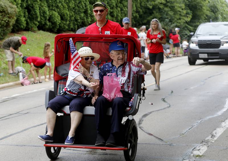 Candy is tossed from riders in a Cycling Without Age pedal car on Sunday, July 2, 2023 during Crystal Lake’s annual Independence Day Parade on Dole Avenue in Crystal Lake. This year’s parade feature close to 100 units.