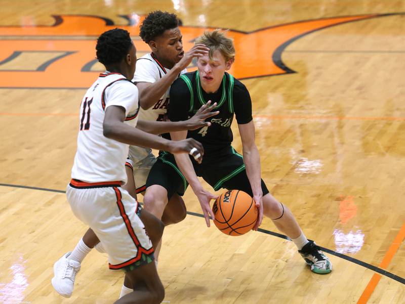 Rock Falls' Connor South is double-teamed by DeKalb's Gabriel Crump (left) and Bryan Miller during their game Tuesday, Dec. 2, 2025, at DeKalb High School.