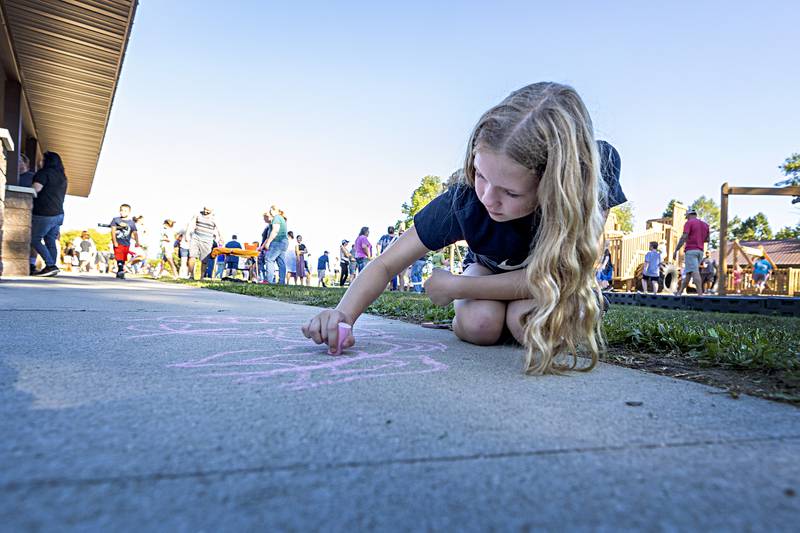 Emily Wendt, 12, sketches some chalk art Thursday, August 31, 2023 at the PTO welcome back to school event. Kids were able to play games, had their face painted or grab a snack from a food vendor.