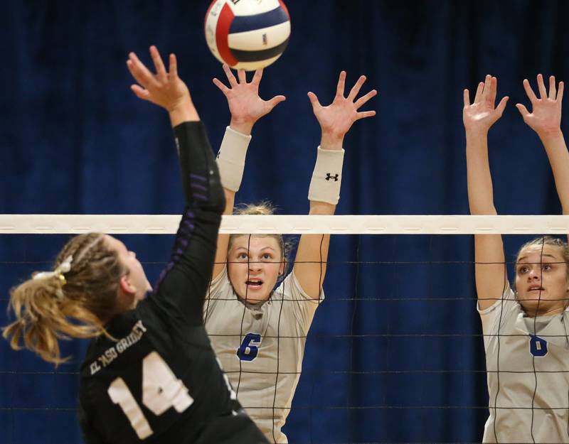 El Paso-Gridley's Addi Hale spikes the ball while Princeton's Caroline Keutzer reaches up to tip the ball as teammate Keighley Davis looks on in the Class 2A Regional Semifinals on Tuesday, Oct. 29, 2024 at Fieldcrest High School.