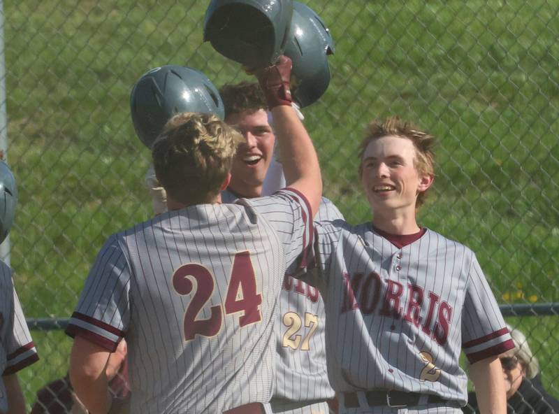 Morris's Carter Snyder greets teammates Cade Lauderman and Landon Norris after hitting a three-run homeer against Ottawa on Monday, April 20, 2026 at Ottawa High School.
