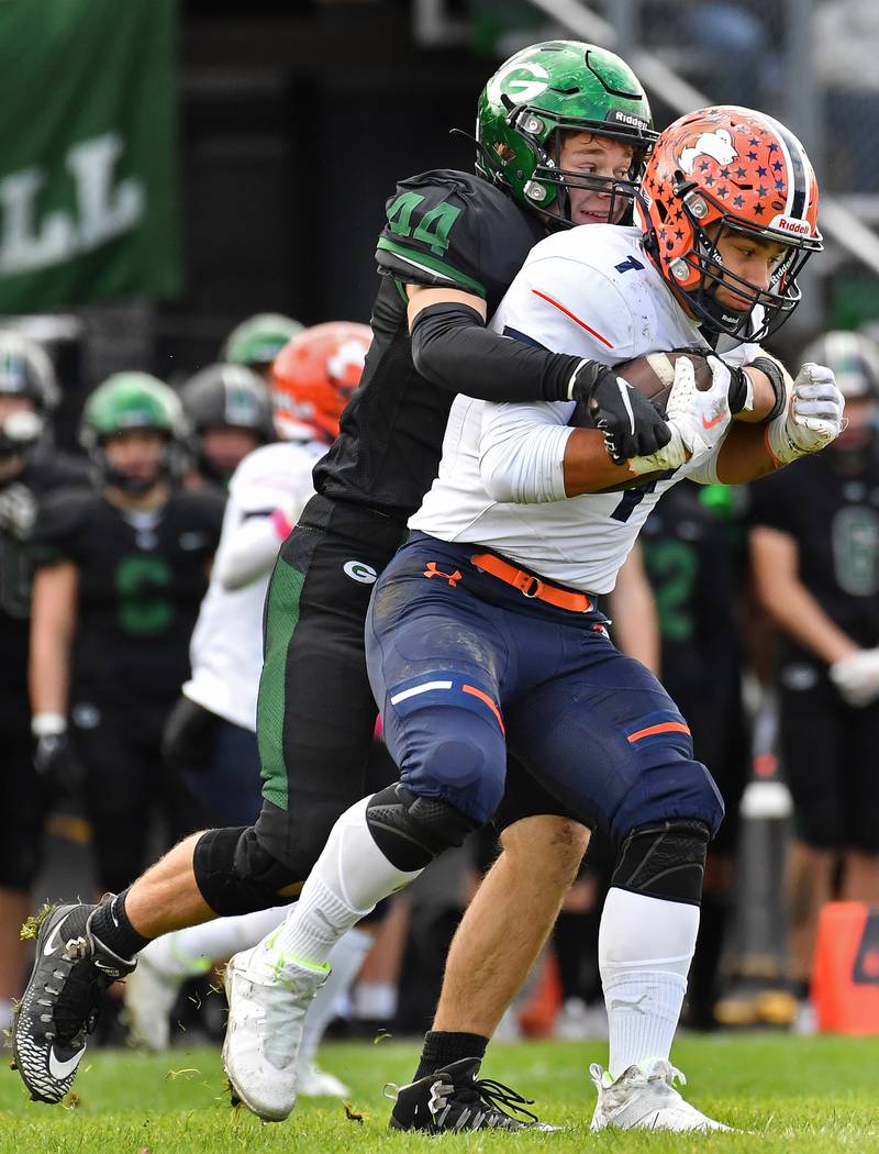 Glenbard West's Ben Troyer (44) grabs Naperville North's Naperville North's Cole Arl (1) from behind during an IHSA Class 8A playoff game on Oct. 28, 2023 at Glenbard West High School in Glen Ellyn.