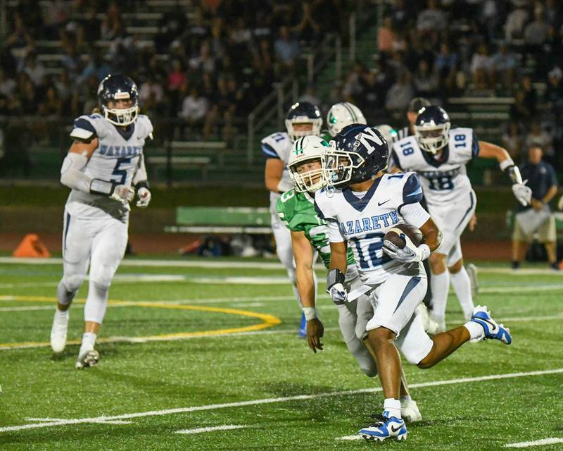 Nazareth Academy's Edward McClain Jr. runs the ball before being tackled by York players during a game Friday Sept. 1, 2023, in Elmhurst.