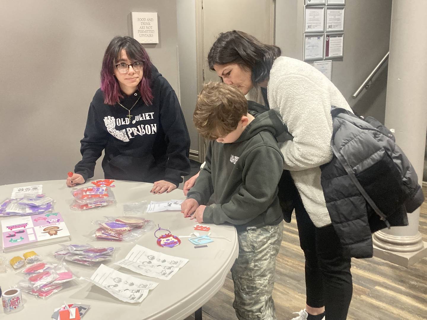 Regina Zavala assists Tadgh McGee and his mom Krysten with crafts at the Joliet Area Historical Museum's Valentine's Day Party on Feb. 8, 2025.