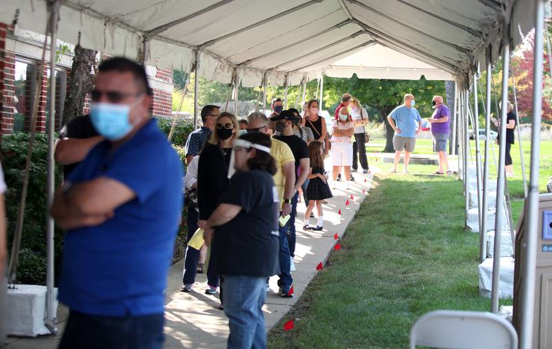 A line of voters forms outside the Kane County Clerk's office in Geneva during the first day of early voting for the 2020 general election on Sept. 24.