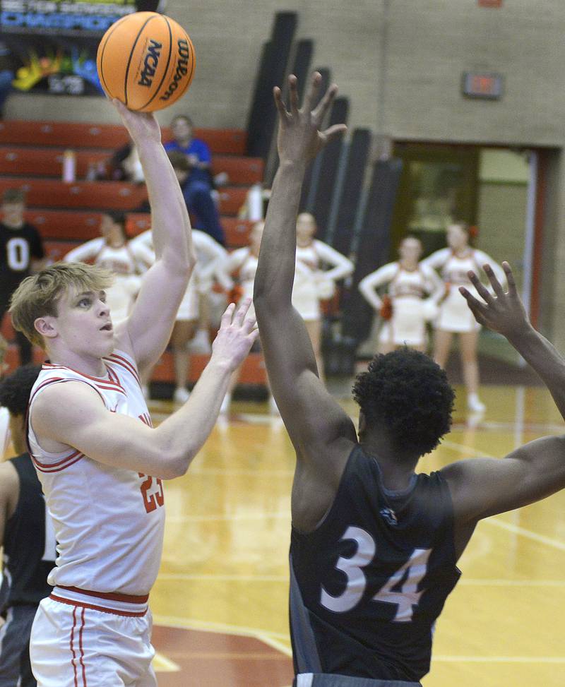 Ottawa’s Owen Sanders makes a toss to the basket over the reach of Kaneland’s Jeffrey Hassan in the 1st quarter Tuesday at Ottawa.