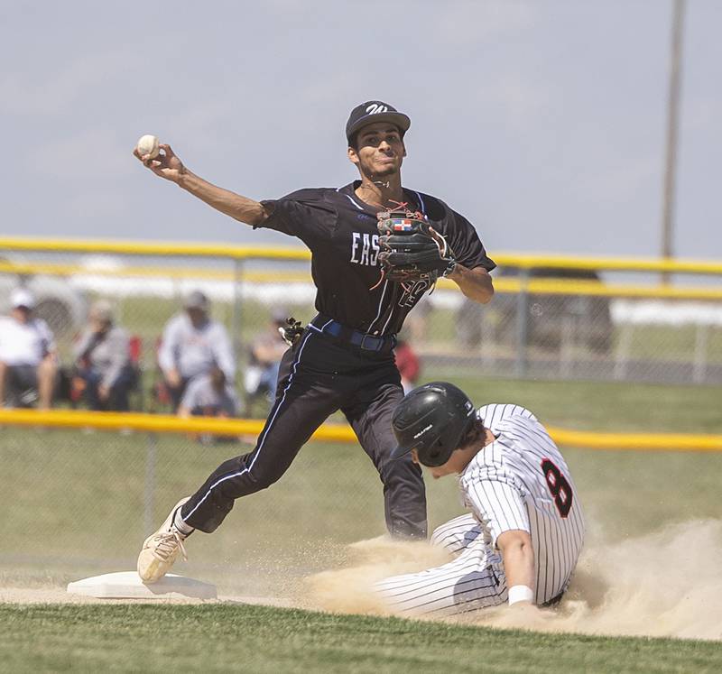 East Dubuque’s Angel Reyes throws to first as Fulton’s James Crimmins looks to break up the double play Wednesday, May 22, 2024 in the Class A sectional semifinal in Forreston.