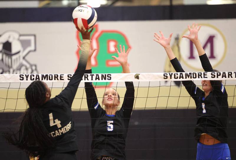 Burlington Central's Emily Maramba (left) and Peyton Strout go up to block Sycamore's Khiara Thomas Tuesday, Oct. 29, 2024, during their Class 3A regional match at Sycamore High School.
