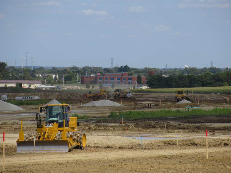 Oswego East High school can be seen from the construction at the southeast corner of Wolf’s Crossing Harvey roads, where Emblem's 13 3-story apartment buildings will be developed by Lennar. Photo taken Sept. 15 2022.