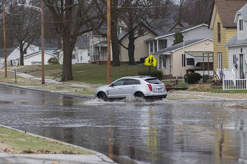 A vehicle traverses high water on Dixon Avenue in Rock Falls Monday, April 3, 2023.