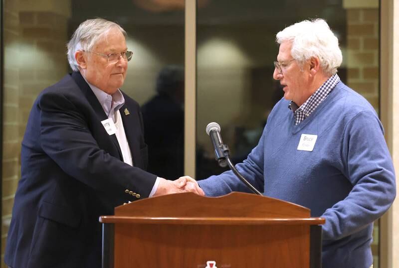 Former DeKalb Mayor Jerry Smith congratulates Bruce Forster as he accepts his late father James Forster’s induction into the Business Leaders Hall of Fame Thursday, Feb. 9, 2023, during the DeKalb Chamber of Commerce’s Annual Celebration Dinner in the Barsema Alumni and Visitors Center at Northern Illinois University.