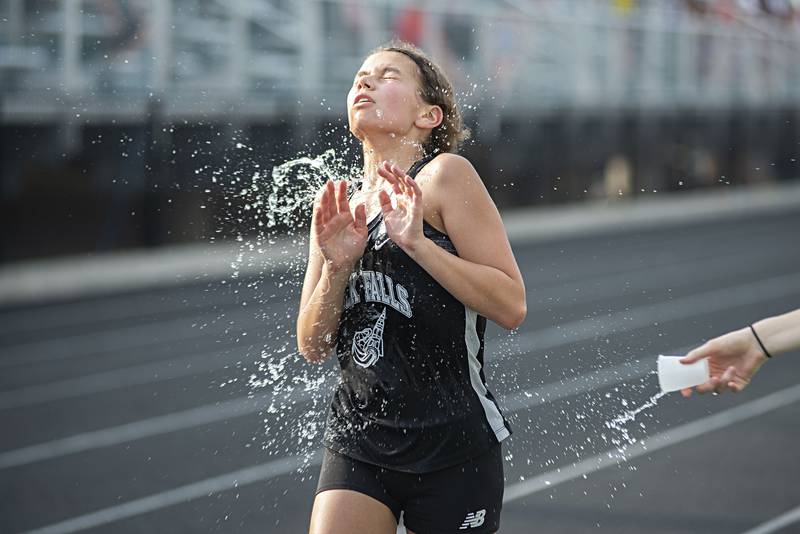 Rock Falls' Elizabeth Lombardo gets a cool splash during the 3200 run at the 2A track sectionals in Geneseo on Wednesday, May 11, 2022.