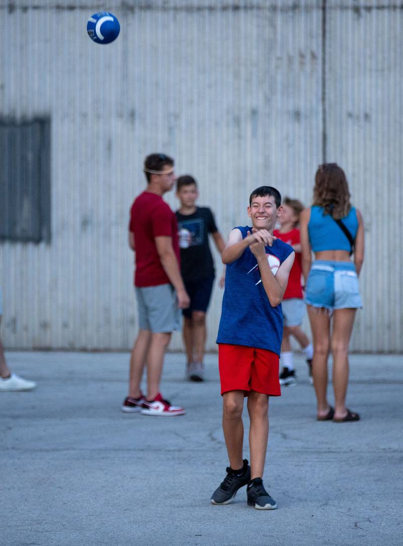 Nathan Beierwaltes of Montgomery  plays catch with his dad during North Aurora's annual Independence Day celebration at Riverfront Park  in North Aurora on Monday, July 3, 2023.