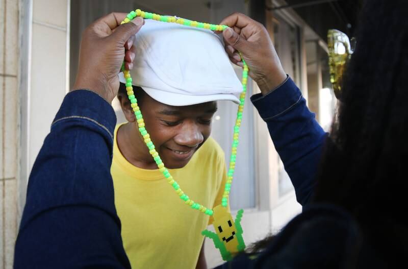 Jordyn Jackson, 16, tries on a corn necklace made by his mom Angela Johnson Friday, Aug. 23, 2024, during the DeKalb Corn Fest in downtown Dekalb.