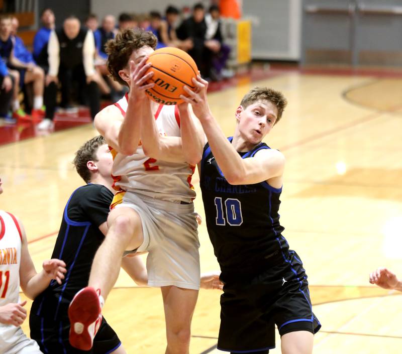Batavia’s Darian Susic (left) and St. Charles North’s Cooper Mellican go after a rebound during a game on Wednesday, Dec. 11, 2024 in Batavia.