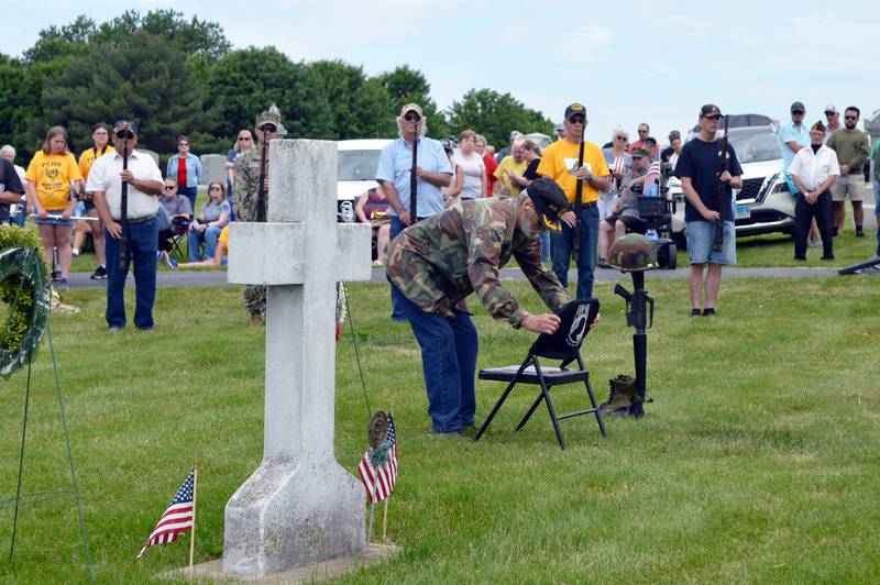 Patrick Fegan American Legion Post No. 83 member Dan Ford places the Prisoners of War/Missing in Action cover on the POW/MIA chair during Polo's Memorial Day ceremony in Fairmount Cemetery on May 29, 2023. The chair is next to a grave dedicated to all unknown soldiers from all wars.