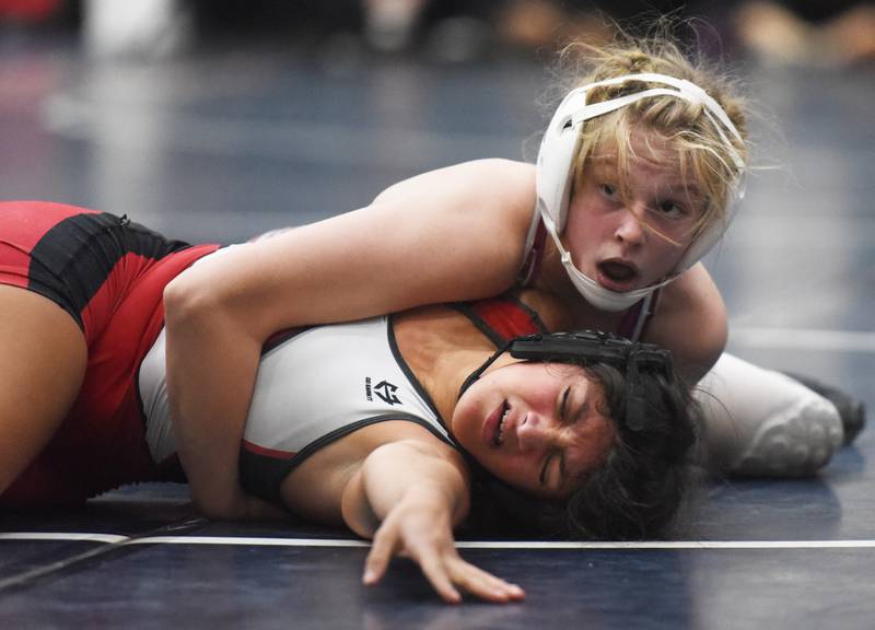 Lockport’s Claudia Heeney, top, and Yorkville’s Yamilet Aguirre compete in the 121-127 pound finals match during the Conant girls wrestling invite in Hoffman Estates Saturday.