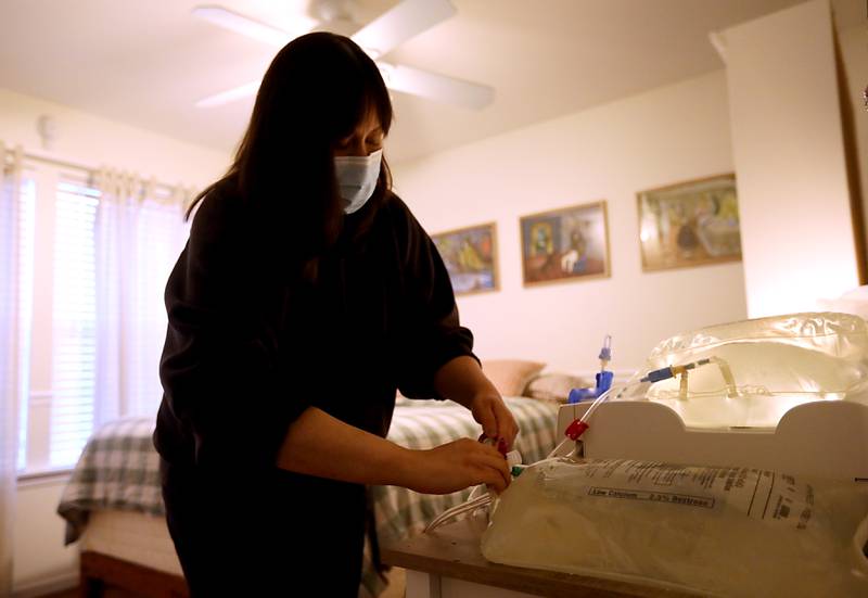 Nicole Leonard, 32, of Lakemoor, hooks herself up to a Peritoneal dialysis machine on Thursday, Aug. 14, 2025 at her home in Lakemoor. She  was diagnosed with kidney disease in 2022 and has created a website and flyers in an attempt to find a living kidney donor.